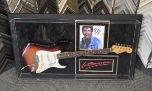 Custom shadow box display featuring a sunburst electric guitar, signed Lou Diamond Phillips photograph, and La Bamba memorabilia mounted in a museum-quality acrylic case.