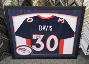 Custom framed Denver Broncos Terrell Davis #30 autographed navy blue football jersey featuring orange and white accents, Broncos team logo, navy matting, and a sleek black frame.